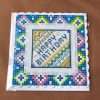 cross stitched Happy Birthday in blue stitching