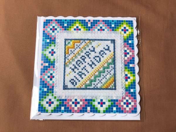 cross stitched Happy Birthday in blue stitching