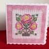 Cross stitched art deco flowers mounted on a white card