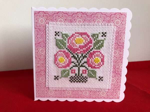 Cross stitched art deco flowers mounted on a white card