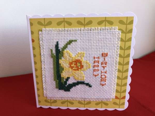 Image of cross stitched daffodil with Happy Birthday written vertically