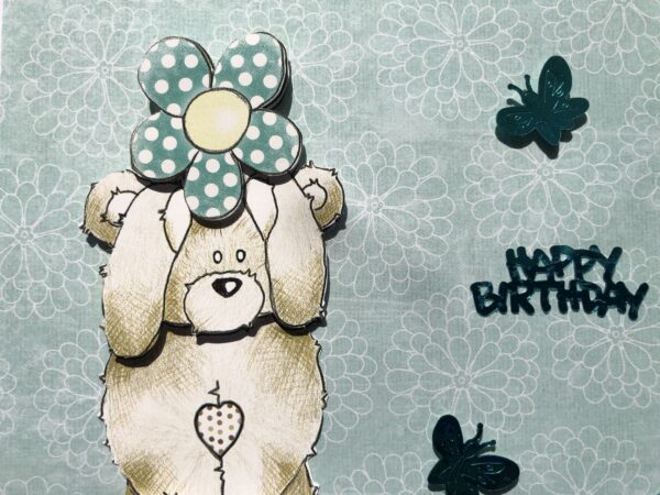 Decoupage birthday card closeup showing teddy holding a flower