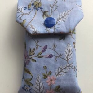 Tissue cover in pale blue floral fabric with royal blue press stud
