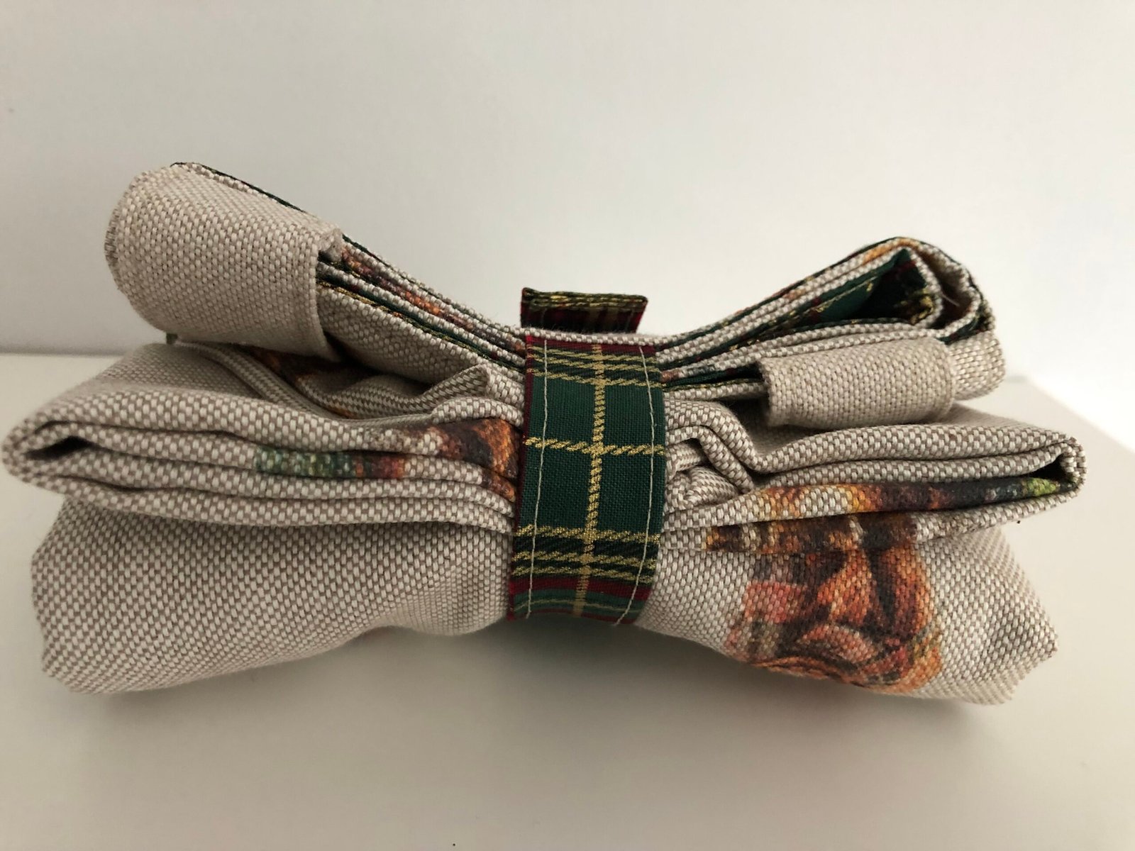 Folded bag closed with strap and press stud