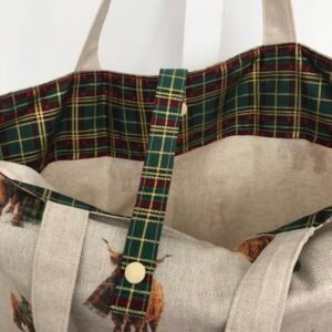 Folding bag showing inside tartan accent and closing strap