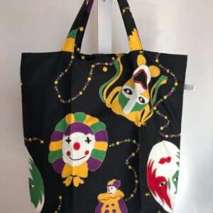 Front of folding bag with a Mardi Gras design with faces masks and clowns